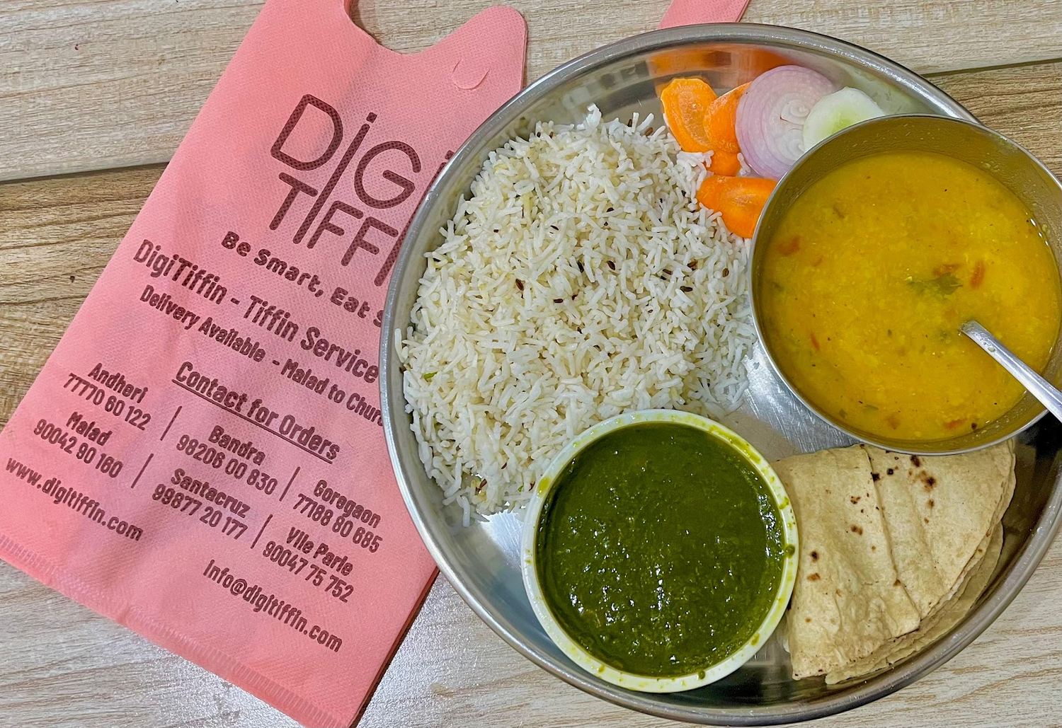 A steel-plate thali from Digitiffin: rice, dal, sabzi and roti